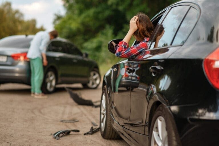 Hombre y mujer conductores tras accidente de coche en carretera. Accidente de automóvil. Automóvil roto o vehículo dañado, colisión de automóviles en carretera. Pasos después de un accidente de coche