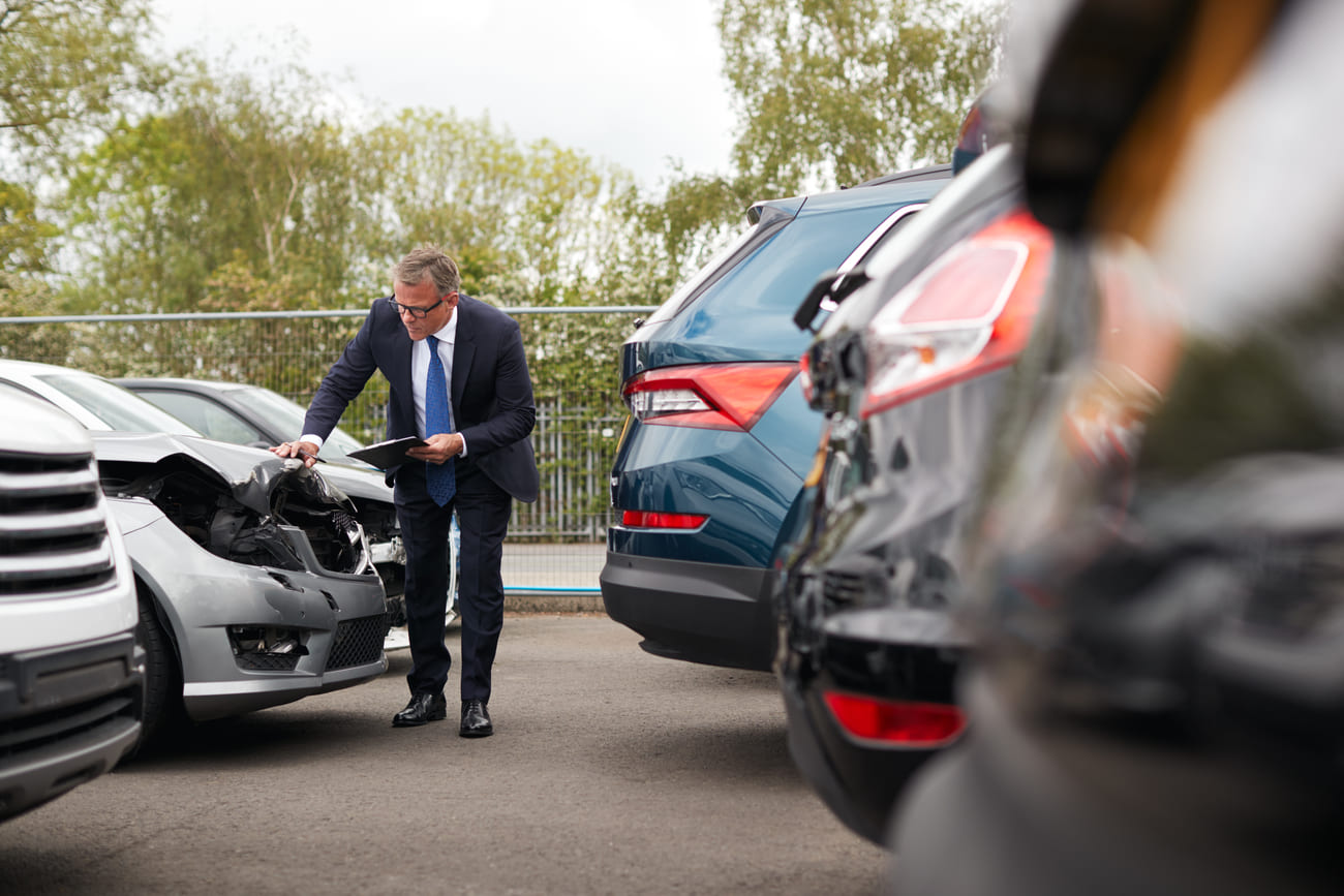 insurance company adjuster looking at vehicle after a car accident