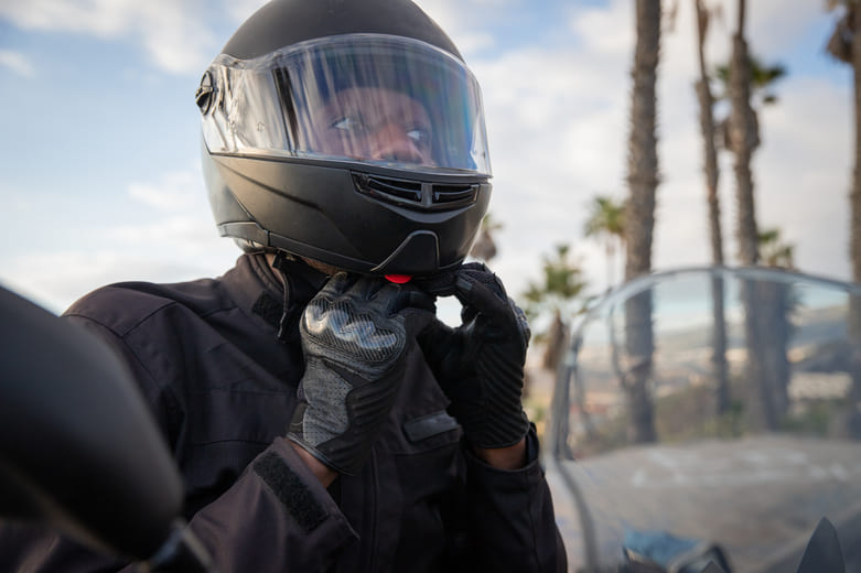man putting on motorcycle helmet